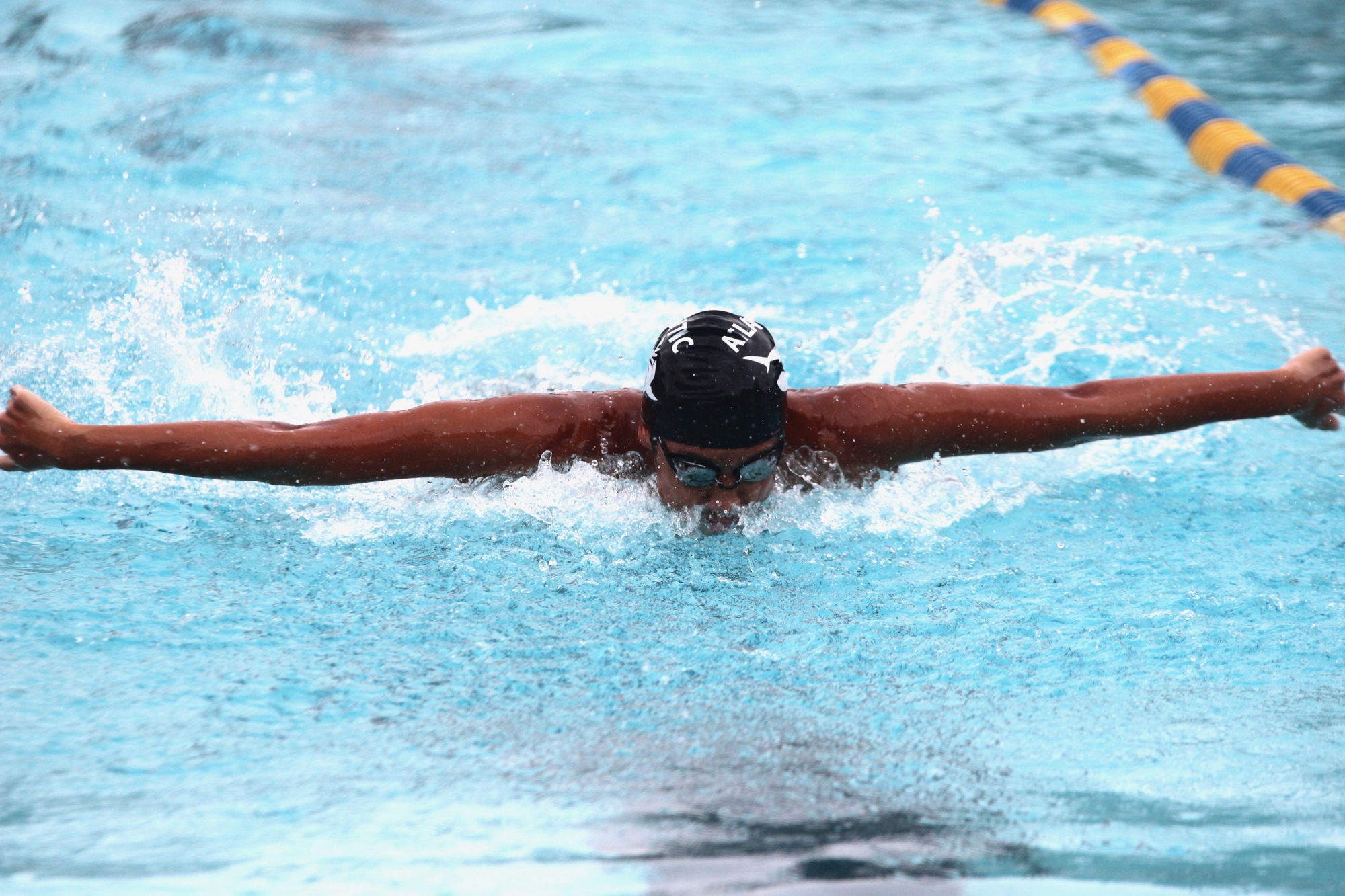 Atlantic swimmer Joseph Yim swims the final leg of the 100-meter butterfly. Photo by Ray Boone