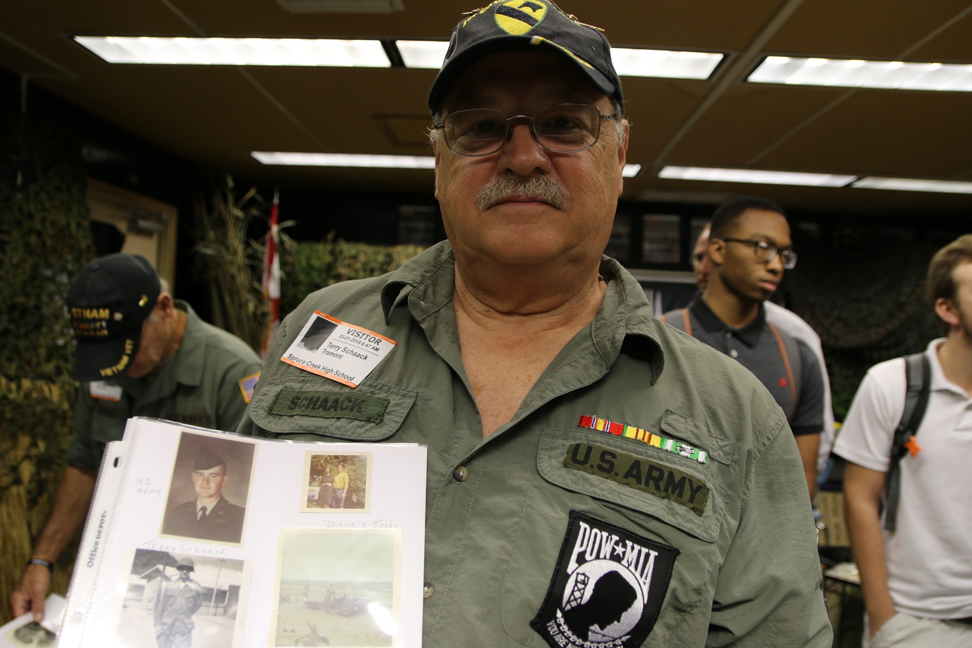 Terry Schaack holds a photograph of himself in uniform. Photo by Nichole Osinski