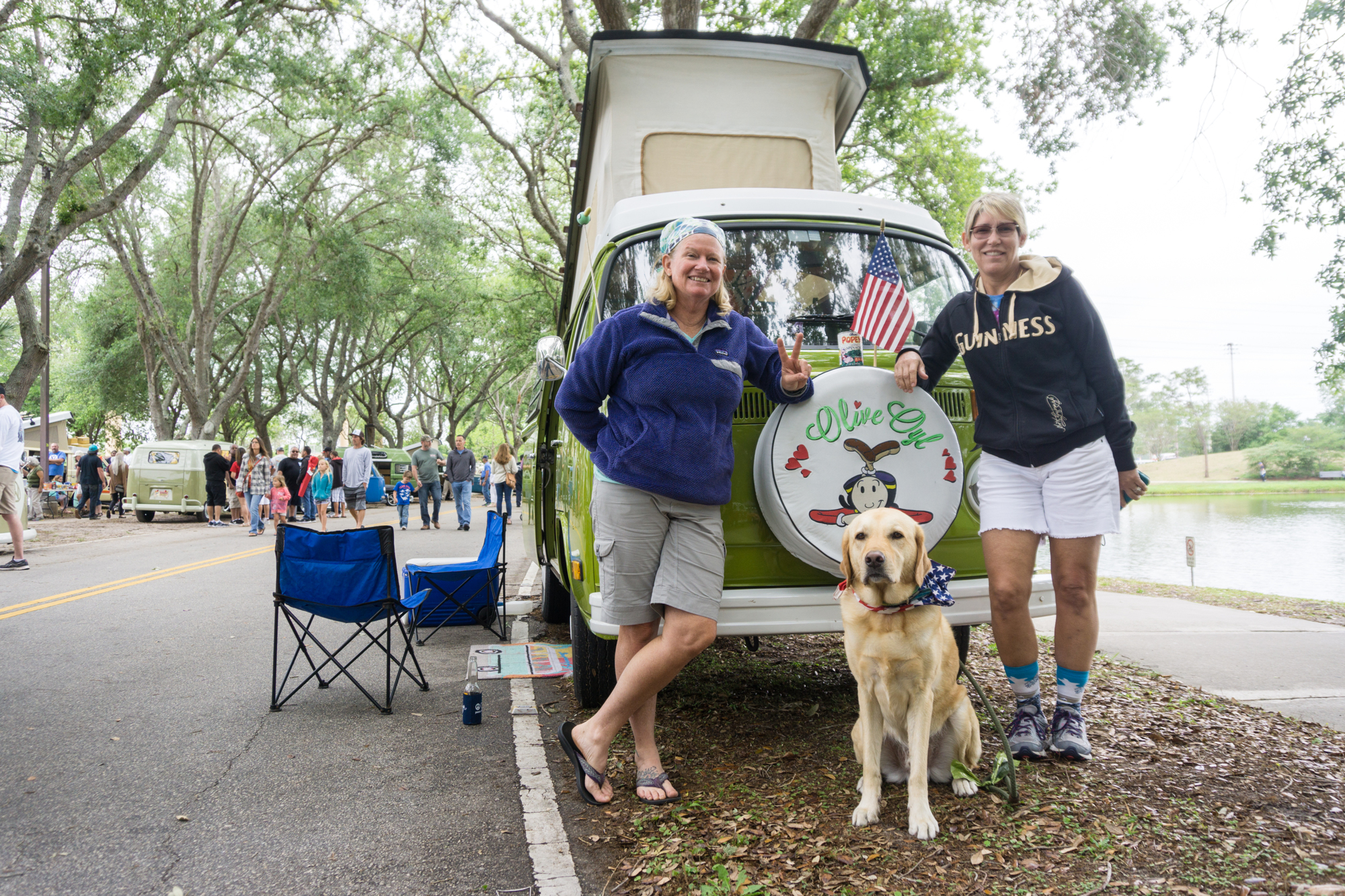 Kelly Byron and Alice Belusko stand with their dog in front of their van Olive.