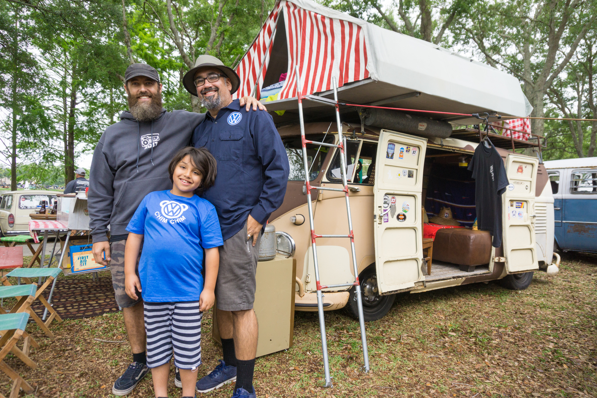 Yuri Bart, Ryan Yepez, and Ted Yepez stand in front of Yuri's modified bus.