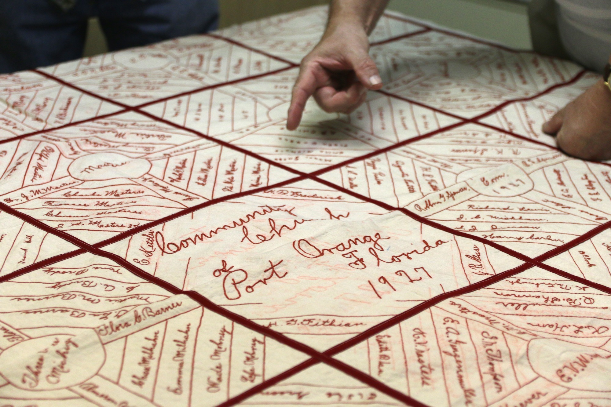 Phil Klema points to a name on the quilt. Photo by Nichole Osinski