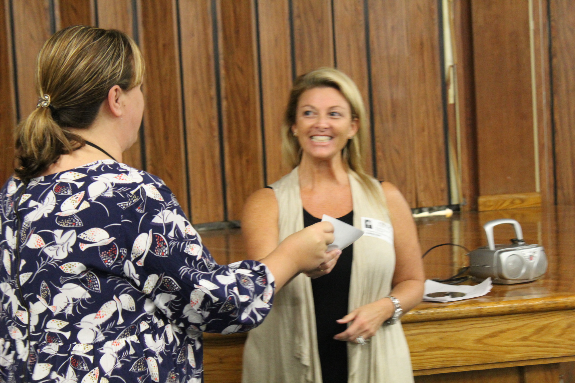 Jenna Pender presents Light The Way's Angela Heaster with a $375  at the Tomoka Elementary multipurpose room on Friday, Oct. 20. Photo by Jarleene Almenas