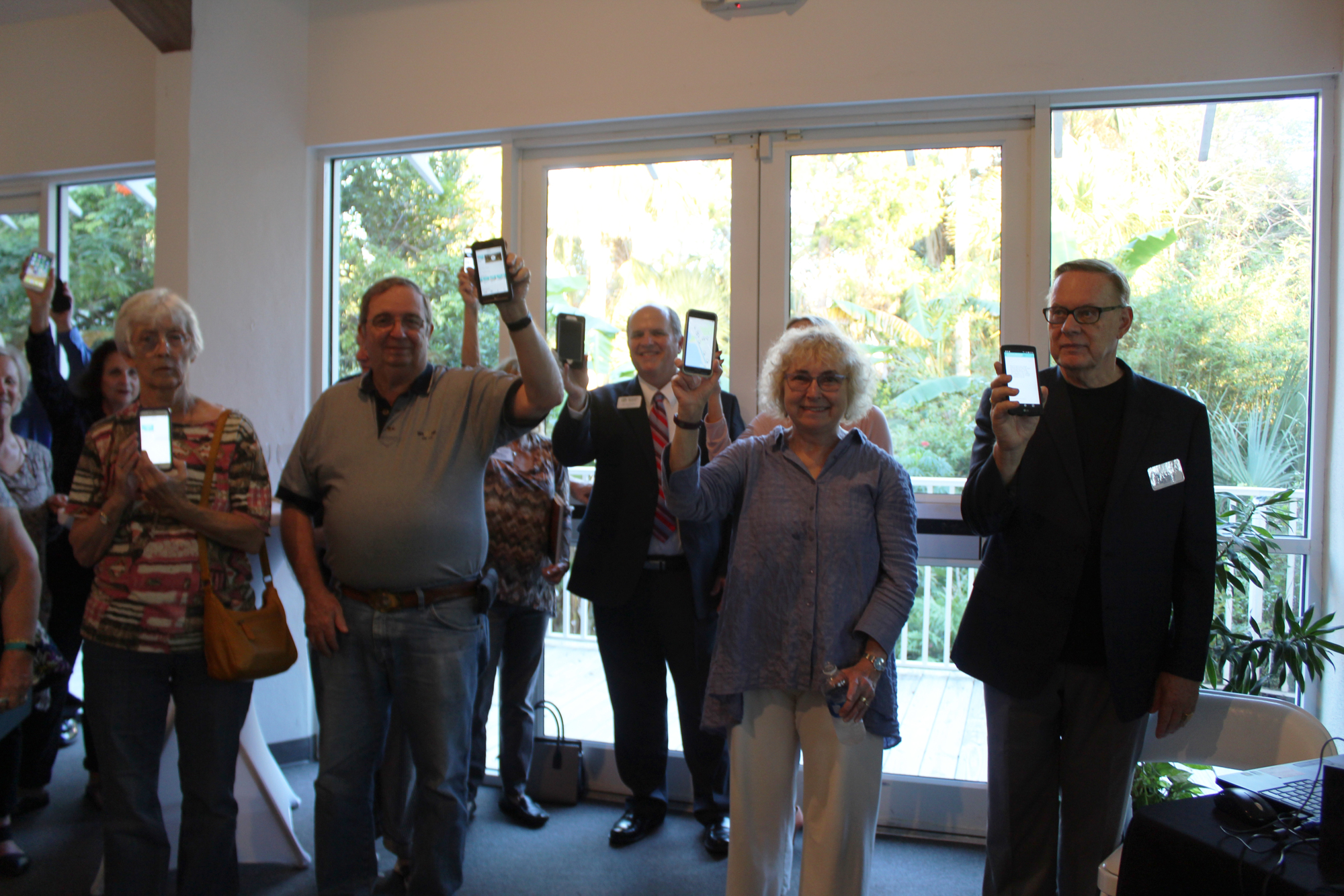 Ormond Beach Mayor Bill Partington and other residents hold up their phones during the Ormond Beach Historical Society's ceremonial app download on Wednesday, Nov. 29. Photo by Jarleene Almenas