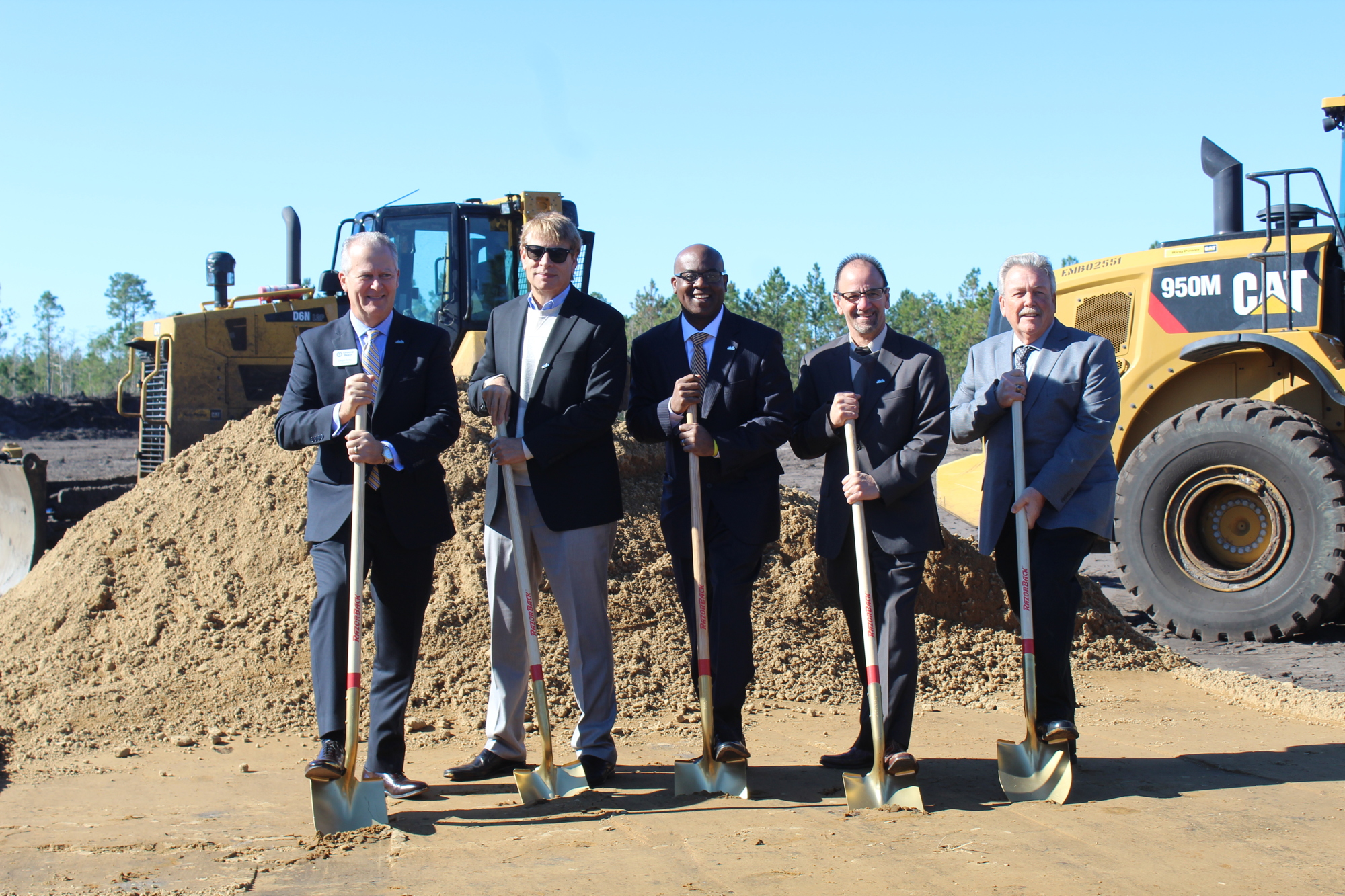 City Commissioner Dwight Selby, Daytona Beach Mayor Derrick Henry and three other First Step Shelter board members get the first dig during the ceremonial groundbreaking on Wednesday, Dec. 13. Photo by Jarleene Almenas