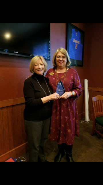 Sissy Spikes, broker, presents the Top Sales Associate Award to Sue Morrison.