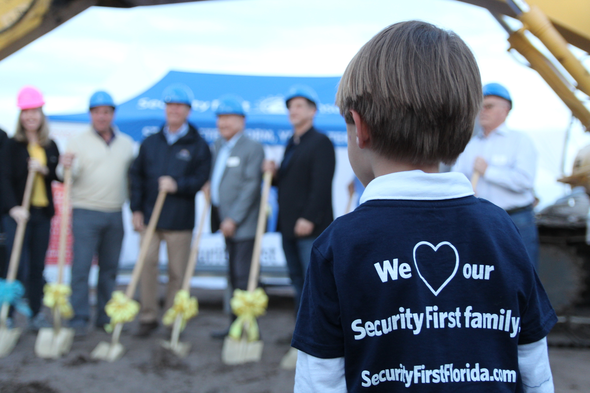 Henry DeVriese looks on as Security First board members break ground during Security First's groundbreaking ceremony for its new headquarters on March 7. Photo by Jarleene Almenas
