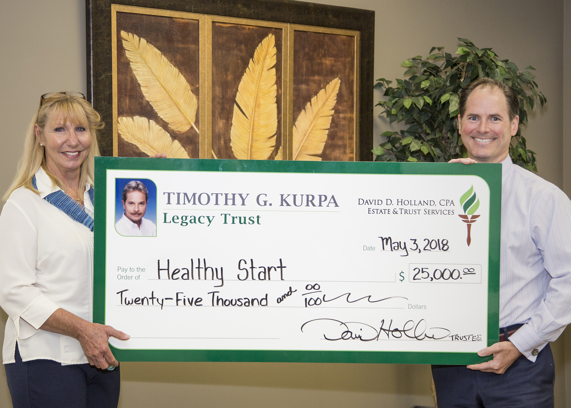 David Holland presents Dixie Morgese, of Healthy Start Coalition, with a check for $25,000.