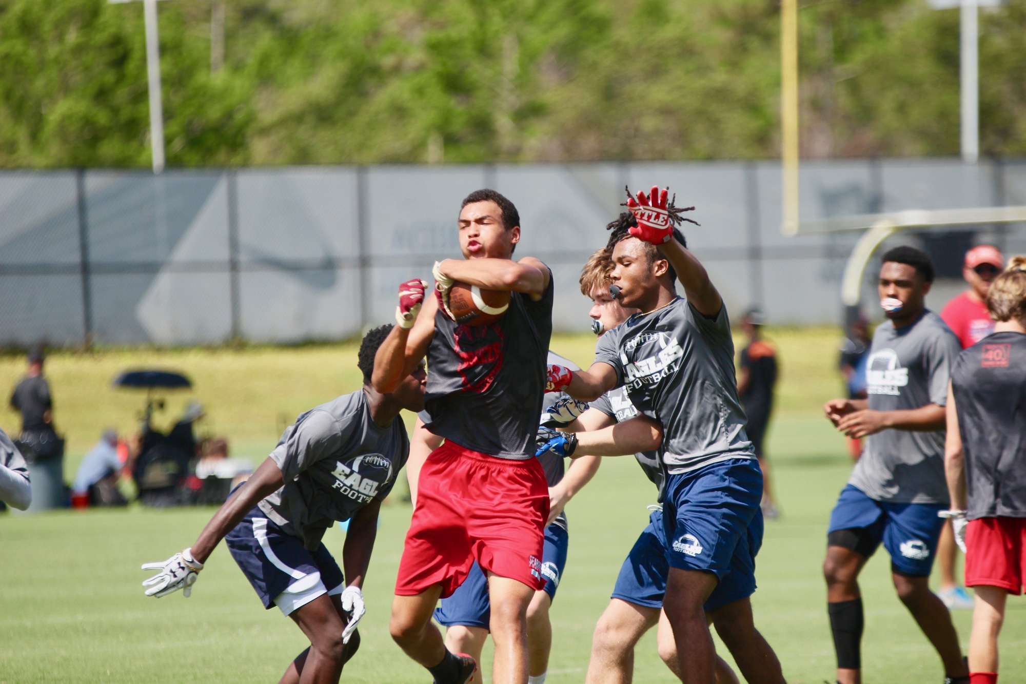Seabreeze's Orion Mountain runs through a pair of defenders at UCF's 7-on-7 camp. Photo by Ray Boone