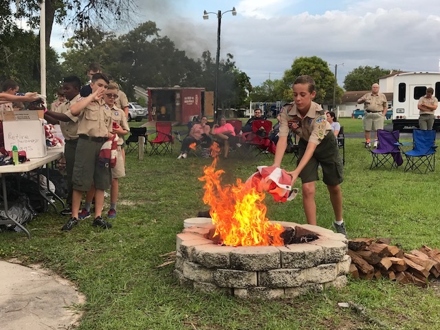 Caleb Wooten tosses a flag into the fire during Troop 403's flag retirement ceremony on June 26. Courtesy photo