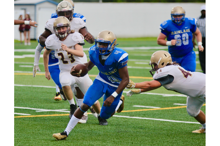 Buccaneers quarterback Taron Keith slips past a defender during Mainland's spring game. File photo