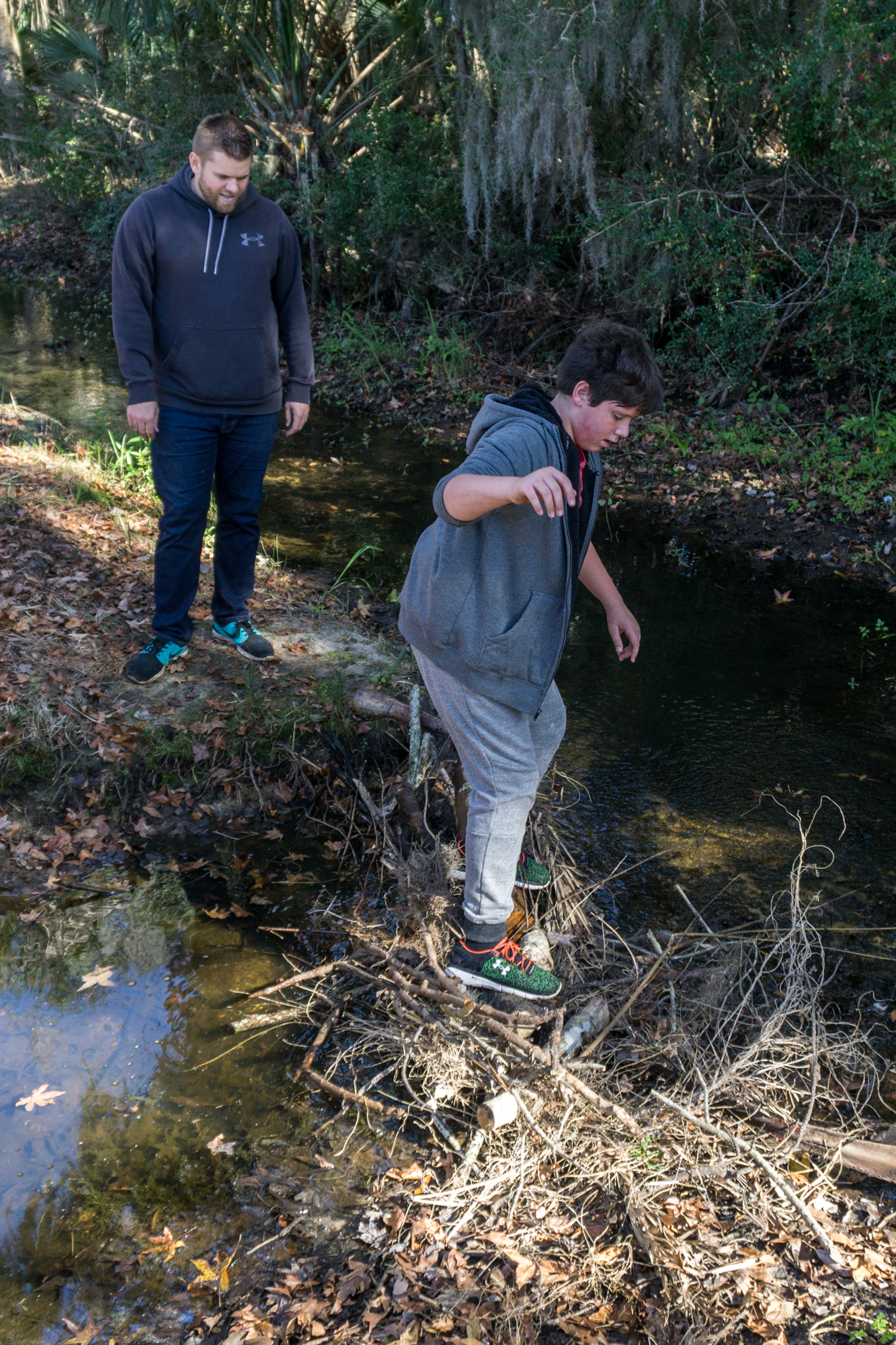 Liam crosses the bridge that Skip helped him build in the creek