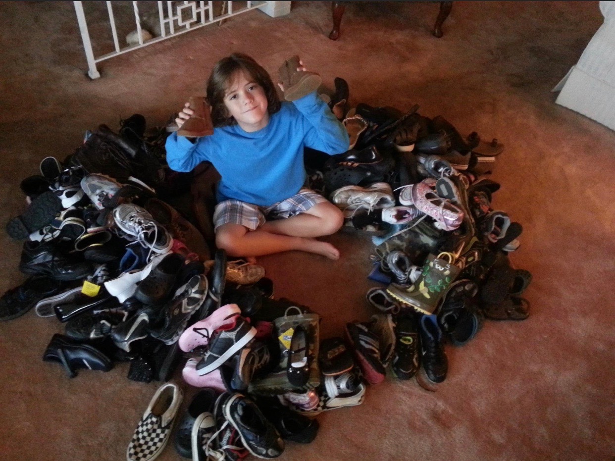 Matthew Monroe at age 8 with pairs of donated shoes in 2012. Courtesy photo