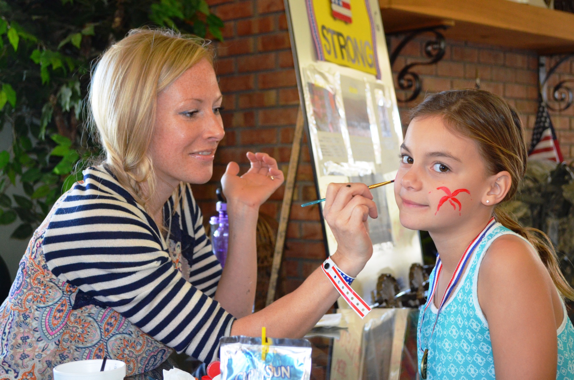 Victoria Maksimyuk has her face painted by Rose Spelman.