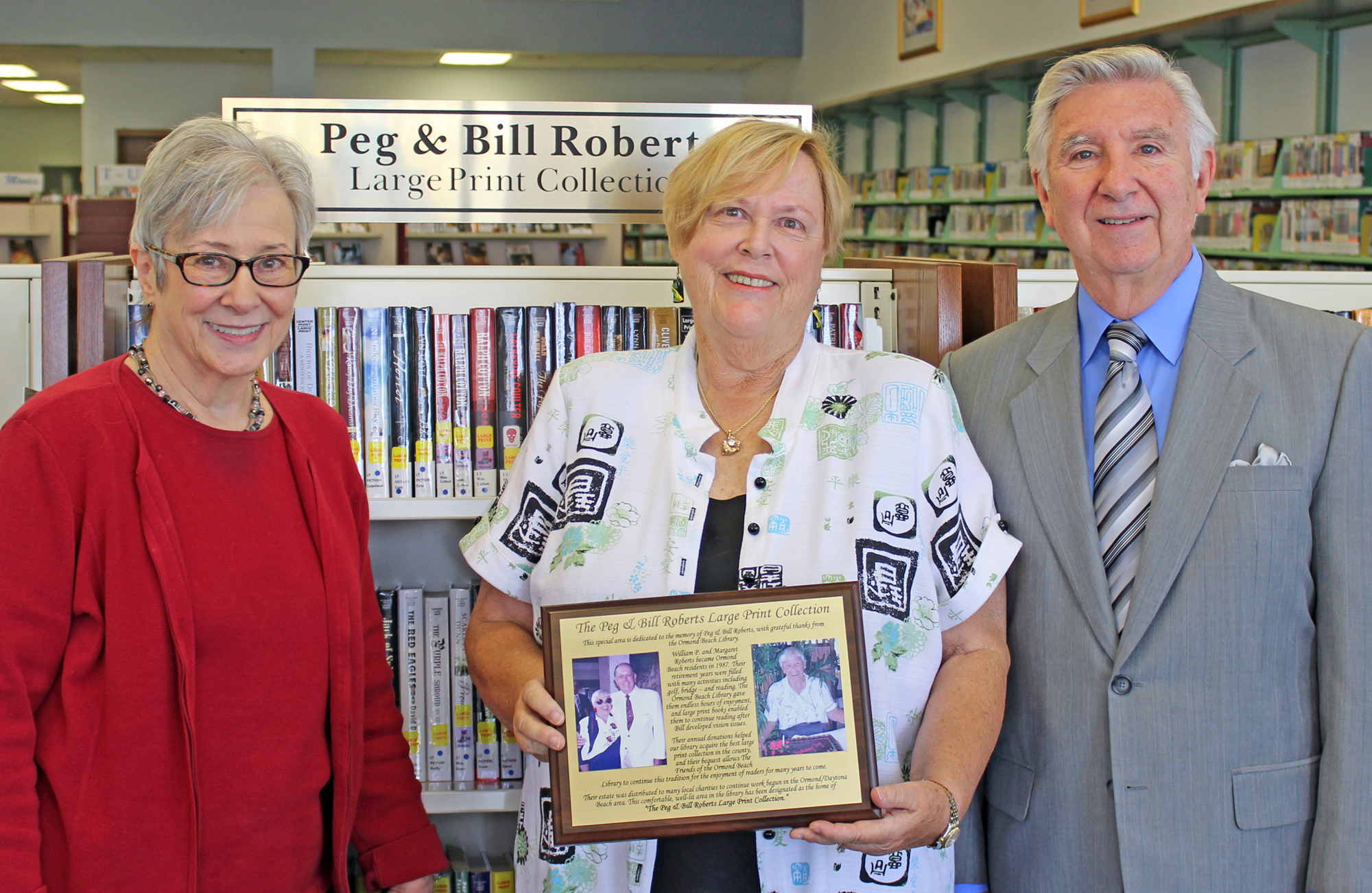 Gana Dunlop, center, accepts an appreciation plaque from Carol Johnson, president of the Friends of Library, and Jerry Brandon, past president.