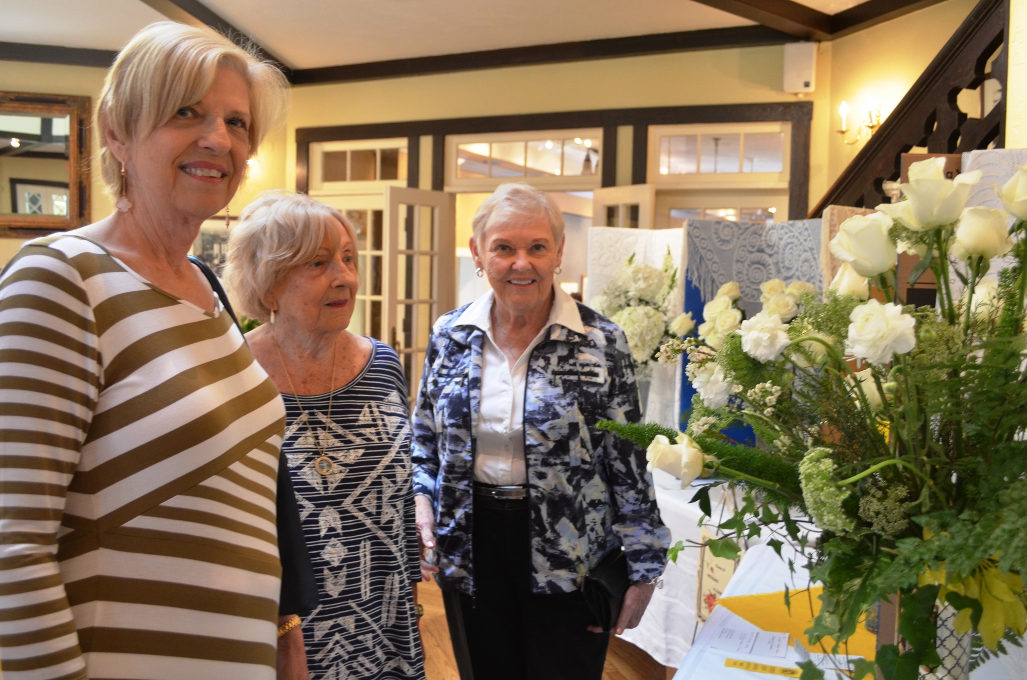 Bonnie Scarborough, Janet Gohn and Carol Smith talk about the flowers on display.