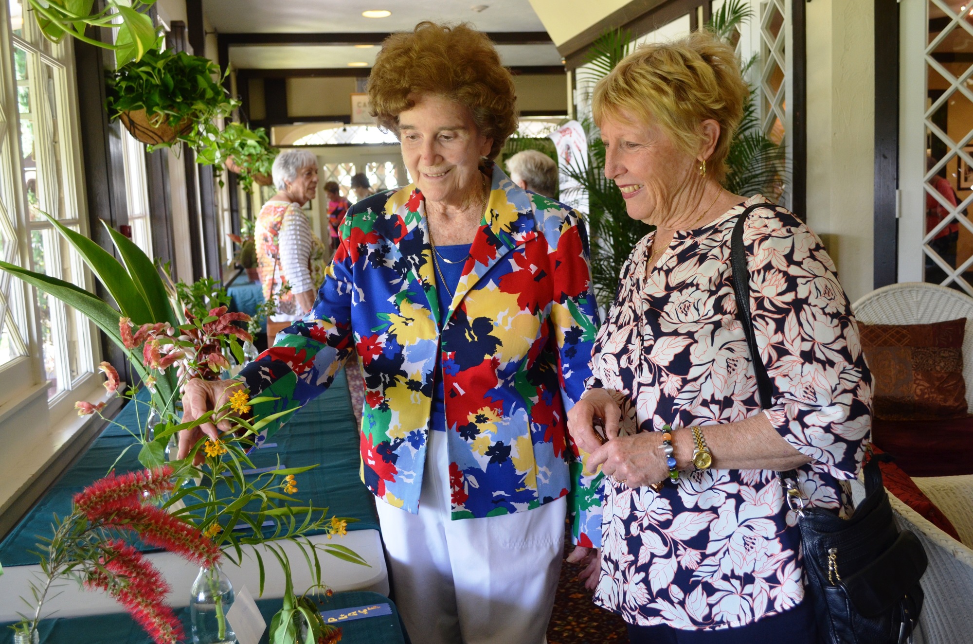 Virginia Young, horticulture chairwoman, and Carol Cababe look at plant cuttings members had brought from their yards.