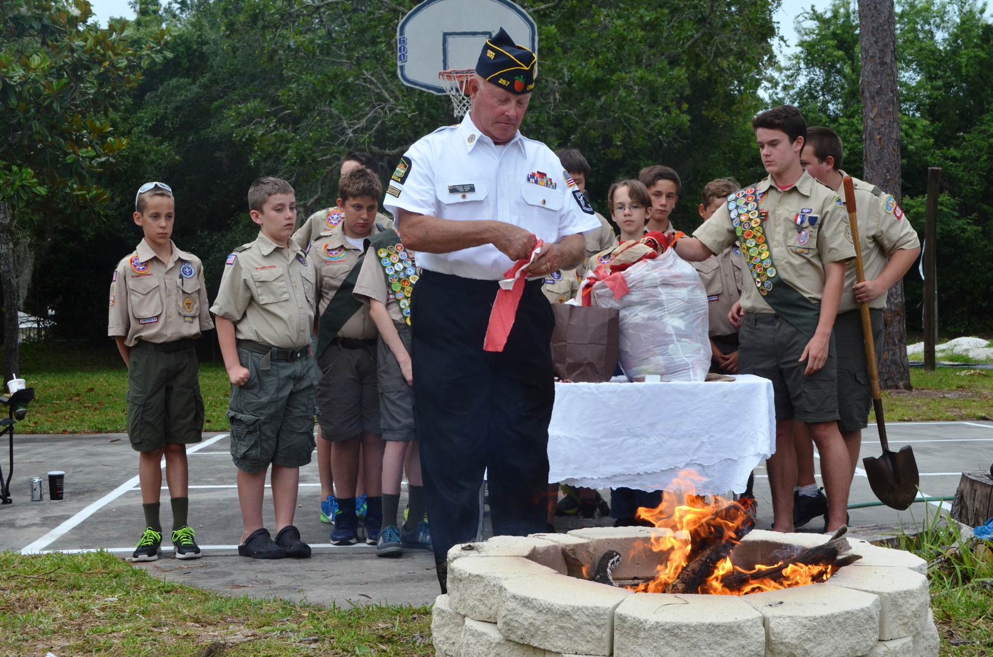 Lawrence Scovotto, honor guard commander, American Legion Post 267, prepares to place part of a flag on the fire.