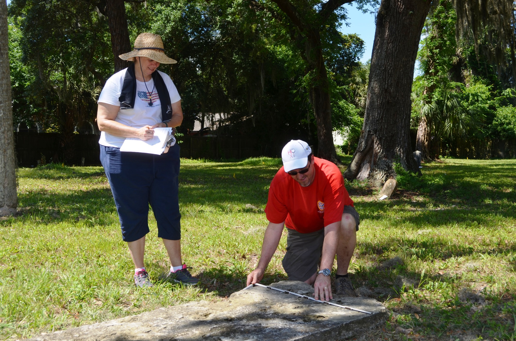Lori Briley and Jeff Serle, parents of scouts, measure a marker.