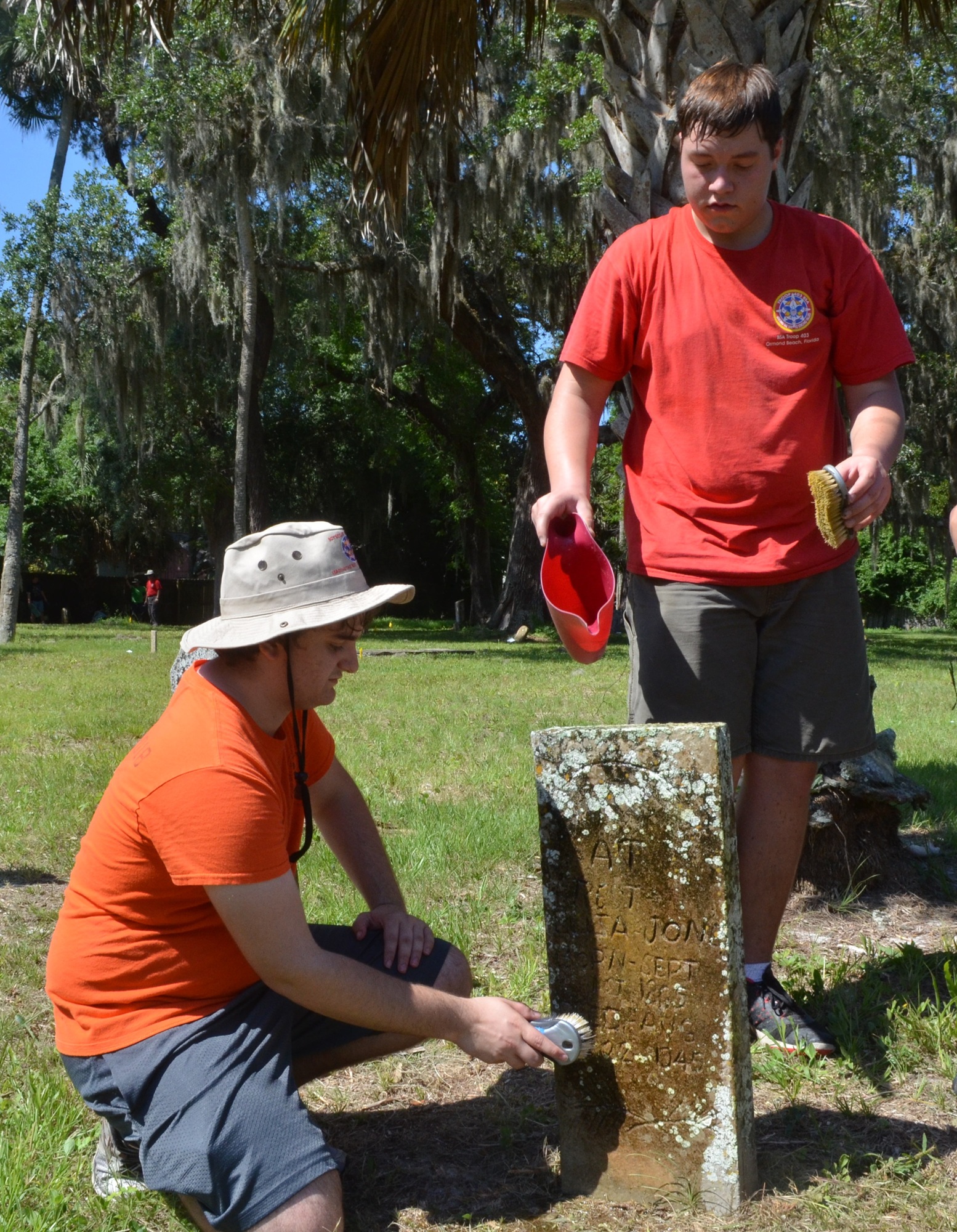 David Truilo and Nick Serle clean a tombstone.