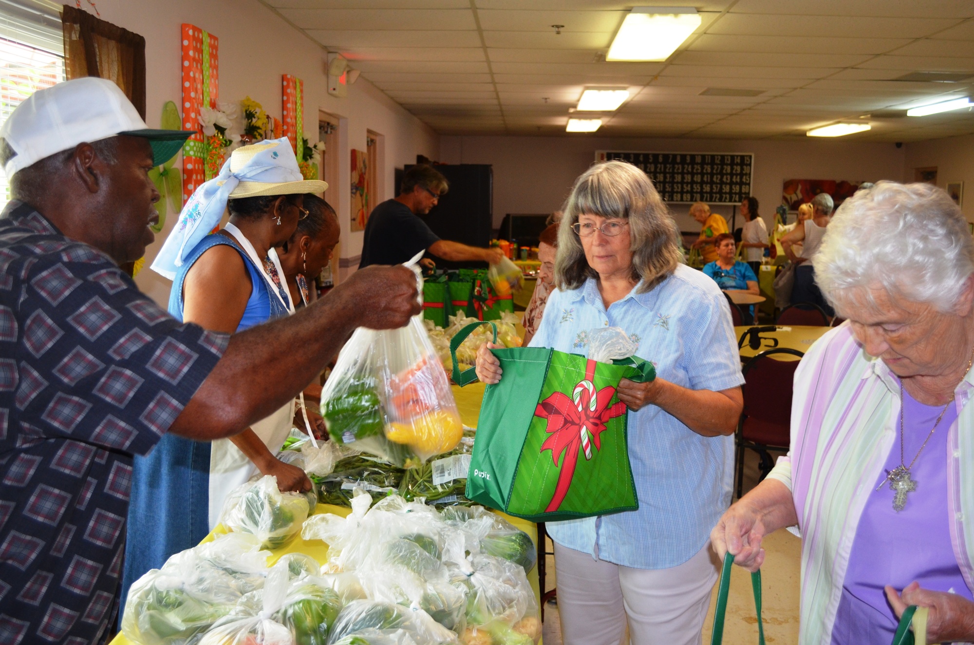 Volunteer Tony Mitchell hands a bag of produce to Janna Shamlaty.