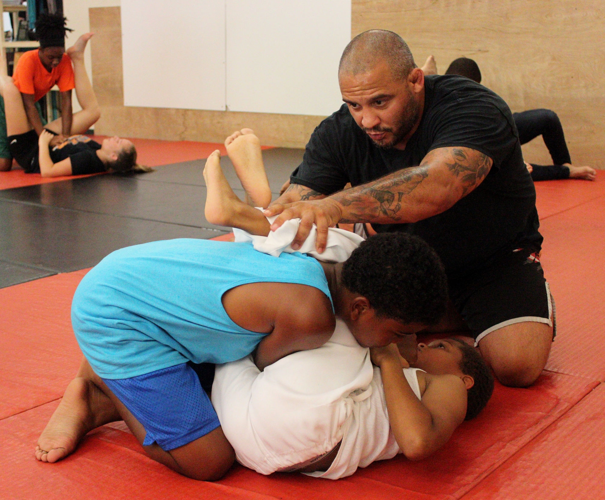 Todd Cutler shows two young students how to perform an arm bar. Photos by Jeff Dawsey