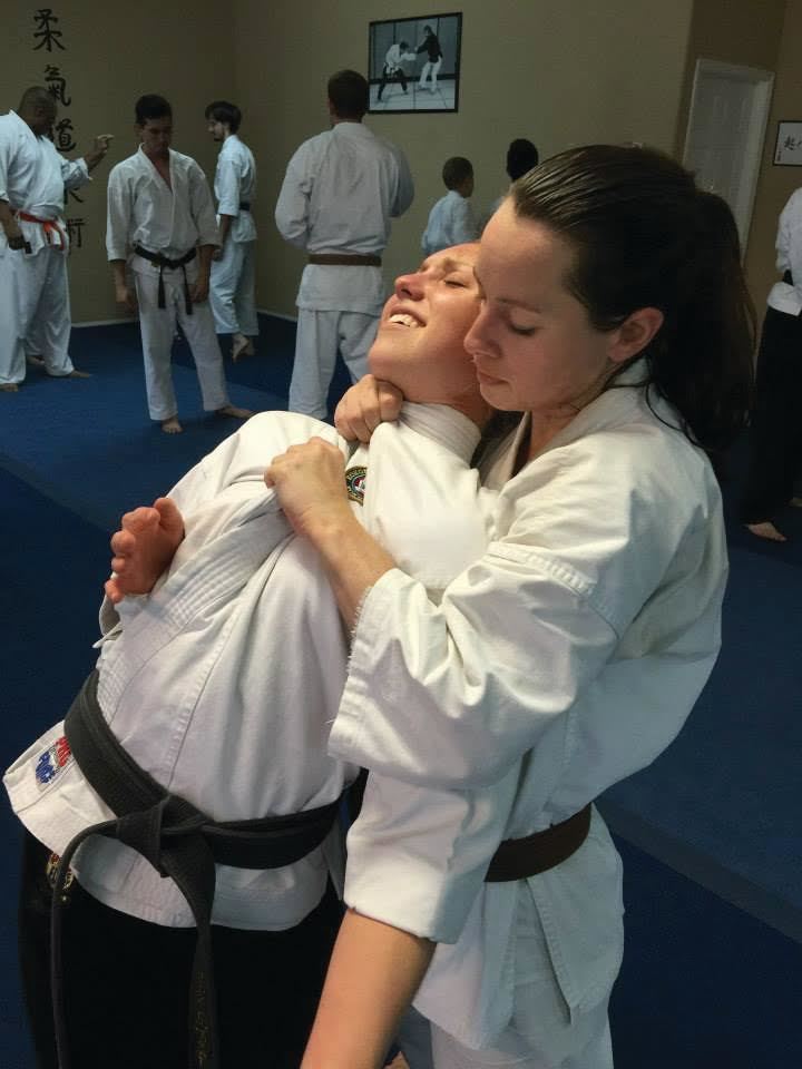 Jenelle Codianne as a brown belt applying a choke to one of her classmates.