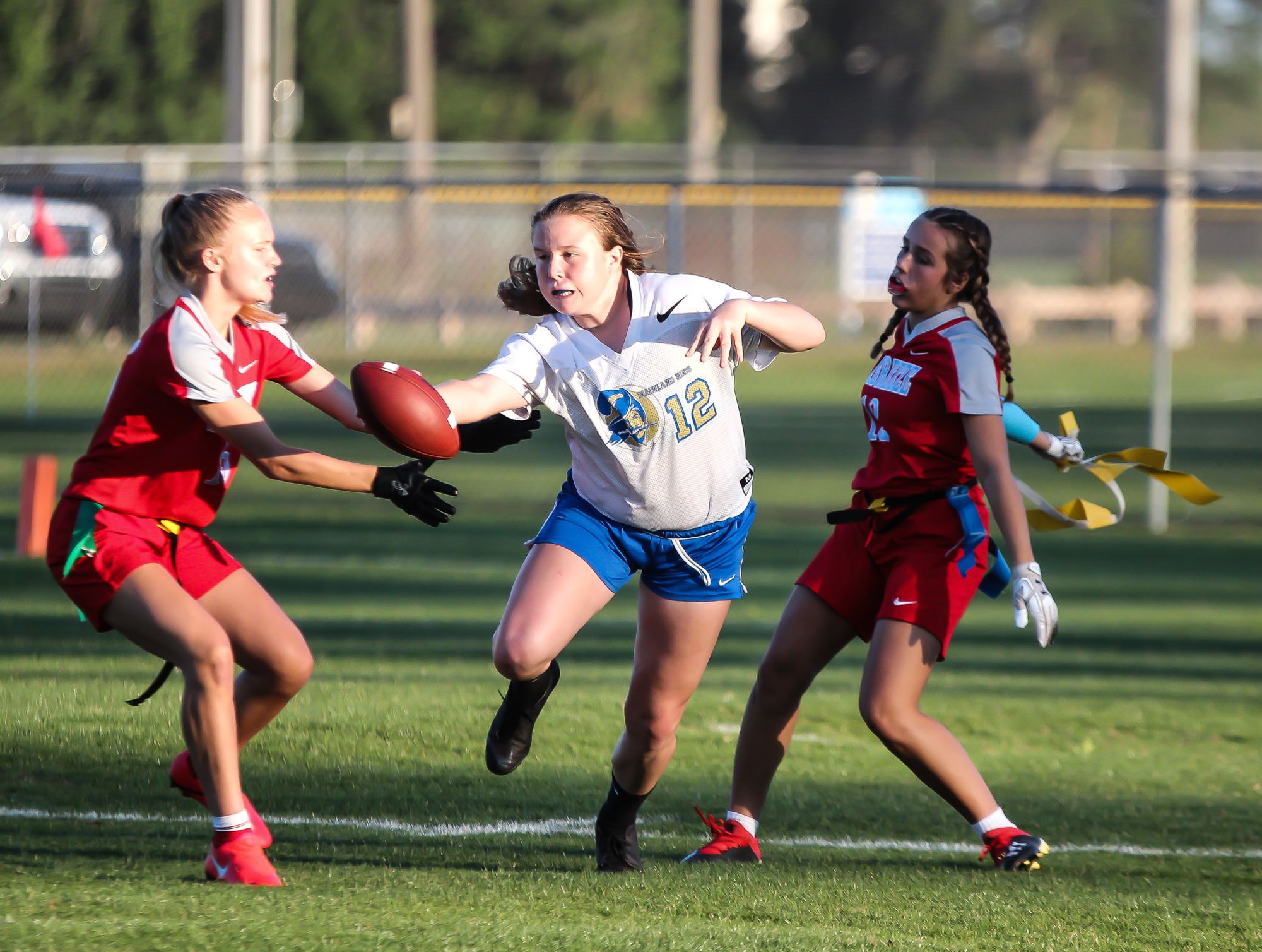 Mainland quarterback Alexa Wilson dodges a pair of defenders in a game against rival Seabreeze. File photo