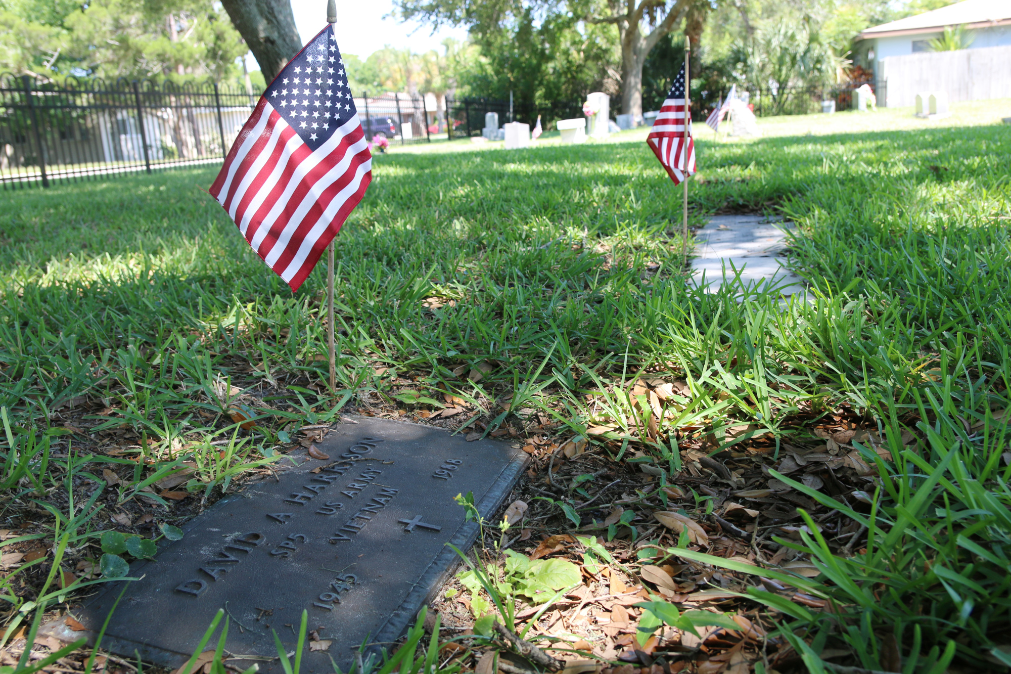 Flags wave in the air by the graves of veterans at Hillside Cemetery. Photo by Jarleene Almenas