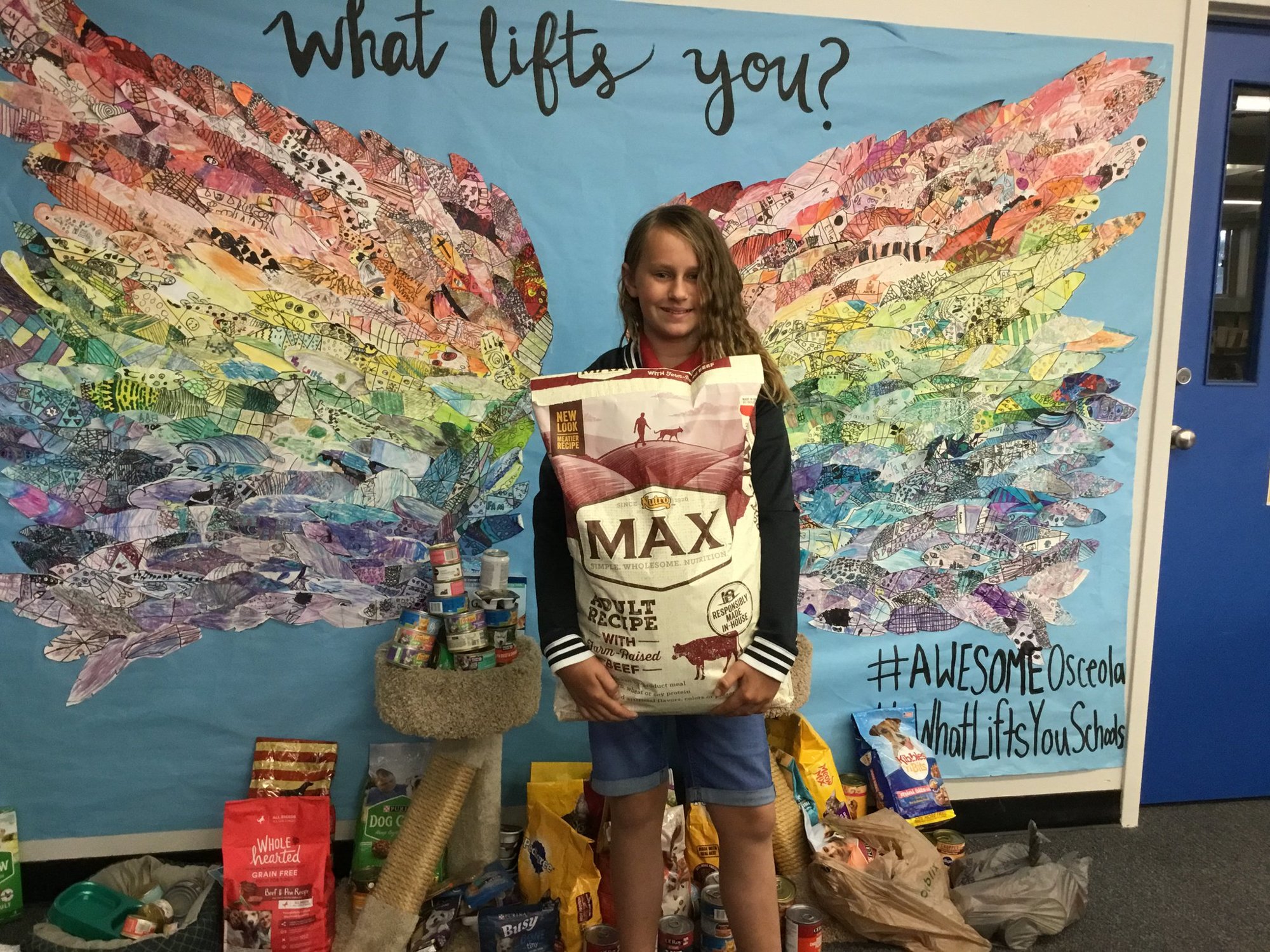 Fifth grader Gwynn Clay brings in a large bag of dog food. Photo courtesy of Jennifer Lastinger