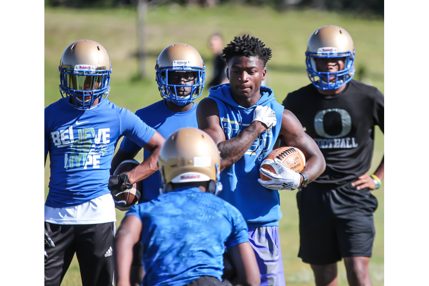 Former Buccaneers running back D'Andre McMillian, who graduated this past spring, coaches during spring practice at Mainland. File photo