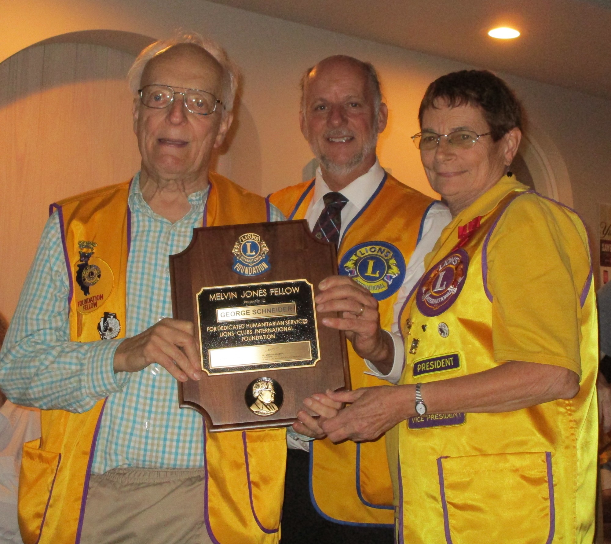 Lion George Schneider is presented his Melvin Jones Fellow by District Governor-Elect Greg Evans and Club President Mary Yochum. Courtesy photo