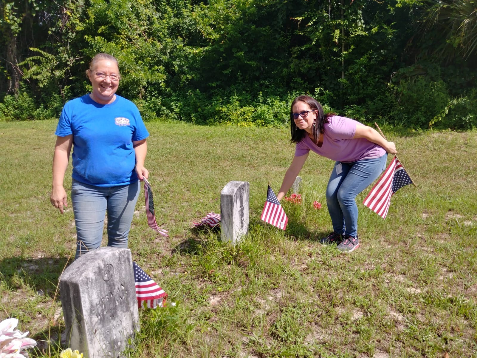 Lowe's employees replace flags at Oakridge Cemetery graves. Courtesy photo