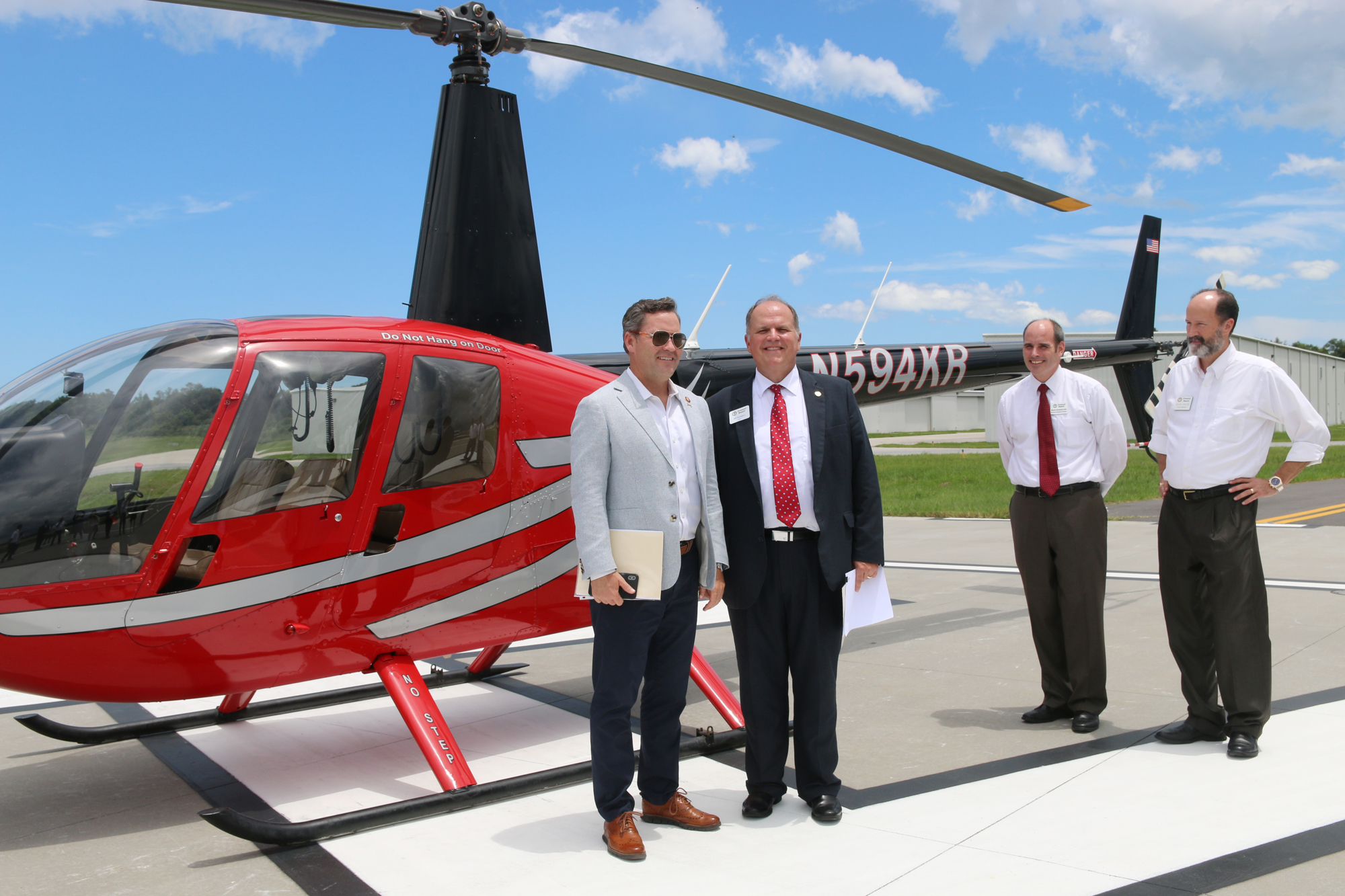 Congressman Michael Waltz and Mayor Bill Partington prepare to board the helicopter as Brian Rademacher and Steven Lichliter watch. Photo by Jarleene Almenas