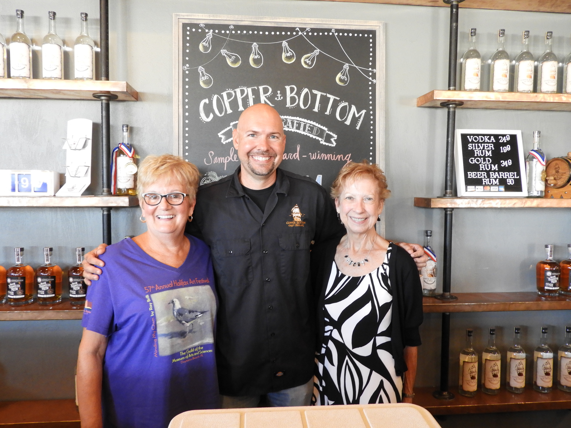 Sherry Erbe, Copper Bottom owner Jeremy Craig, and Patron Party Chair Gloria Keay. Courtesy photo