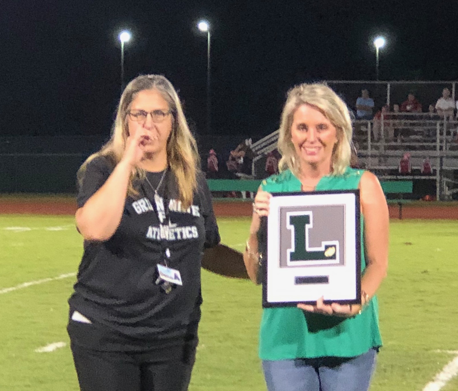Father Lopez principal Leigh Svajko recognizes Dr. Whitney Shoemaker on the field during homecoming on Friday, Oct. 11. Courtesy photo