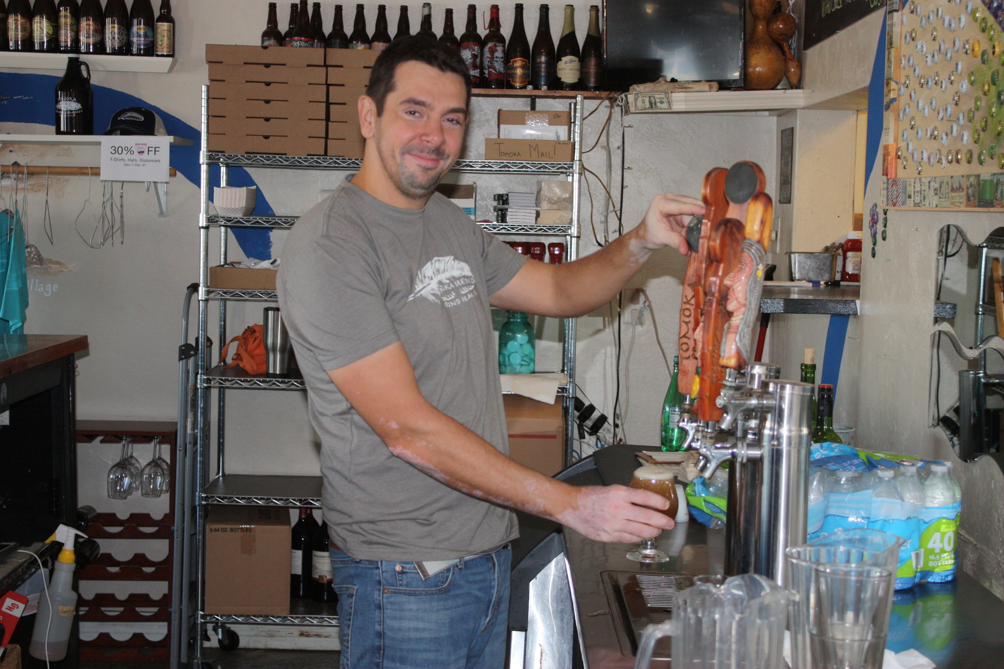 Pete Szunyogh pours one of the last beers at Tomoka Brewery. Photo by Wayne Grant