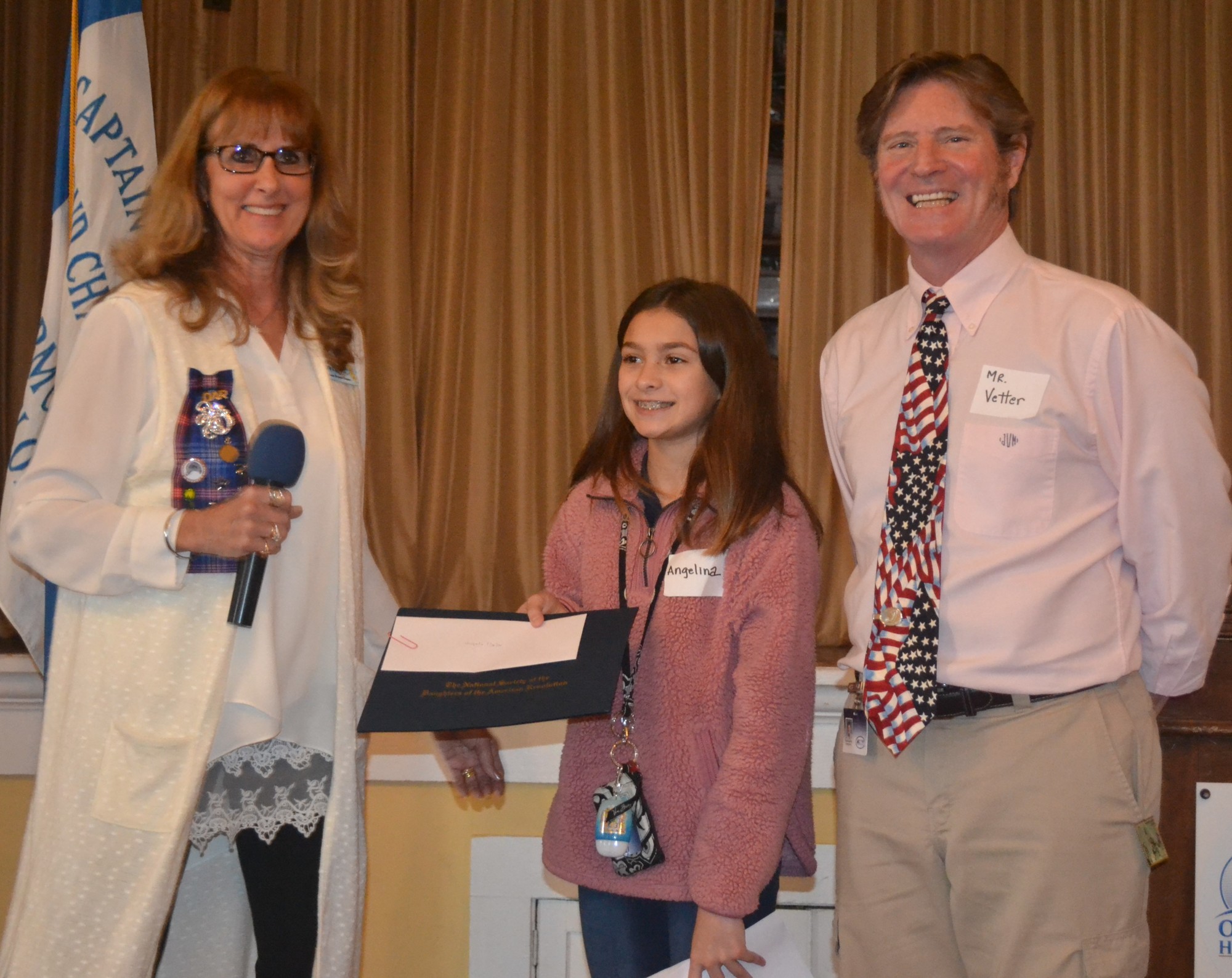 Karen Knowles, American History Chair, presents eight grade second place winner  Angelina Porter, from Hinson Middle School, with her award accompanied by her teacher Joe Vetter. Courtesy photo