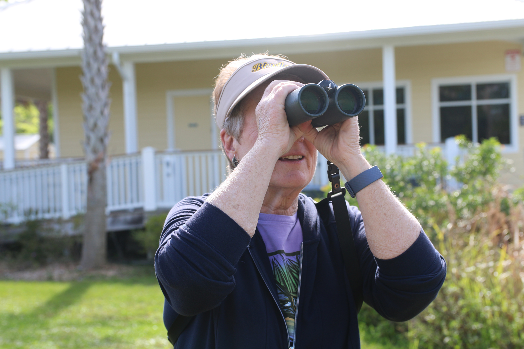 Joan Tague looks through her binoculars at the Environmental Discovery Center. Photo by Jarleene Almenas
