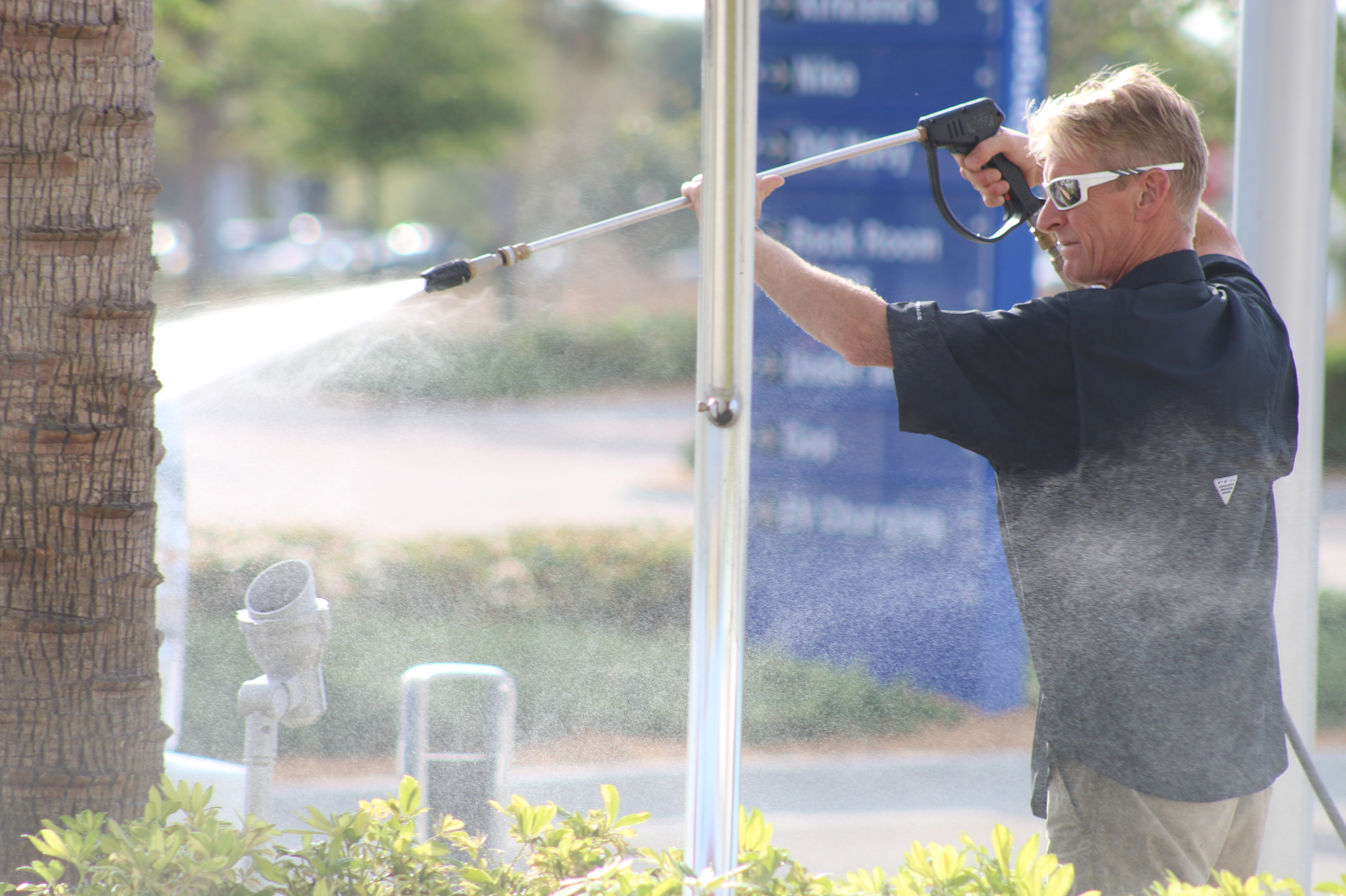 Chris Cope cleans the splash pad at Tanger Outlets on Wednesday, March 18. Photo by Jarleene Almenas