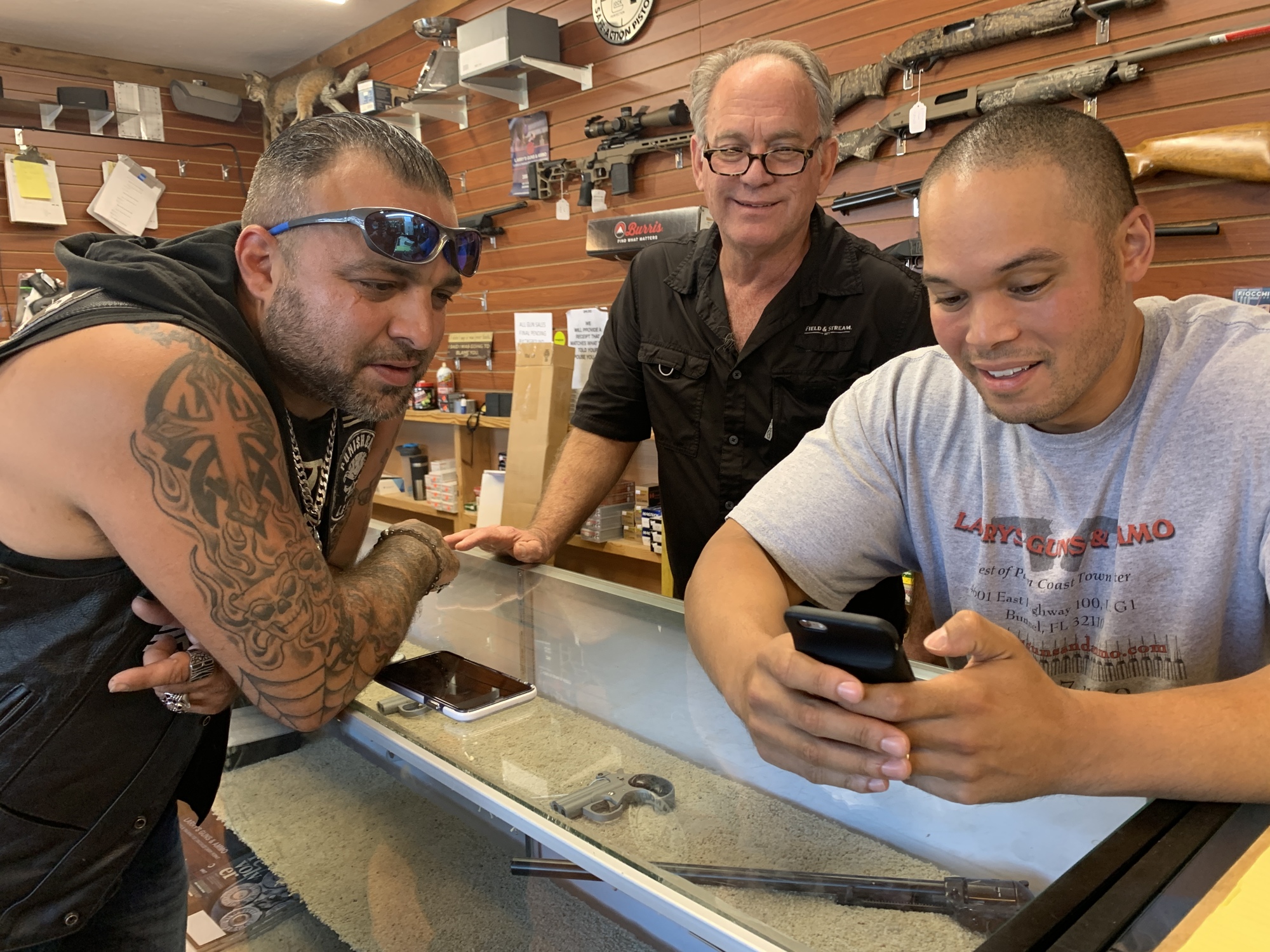 Customer Joe Colmone, with Larry's Guns and Ammo owner Larry Beighle and Manager Kirk Chong. Photo by Brian McMillan