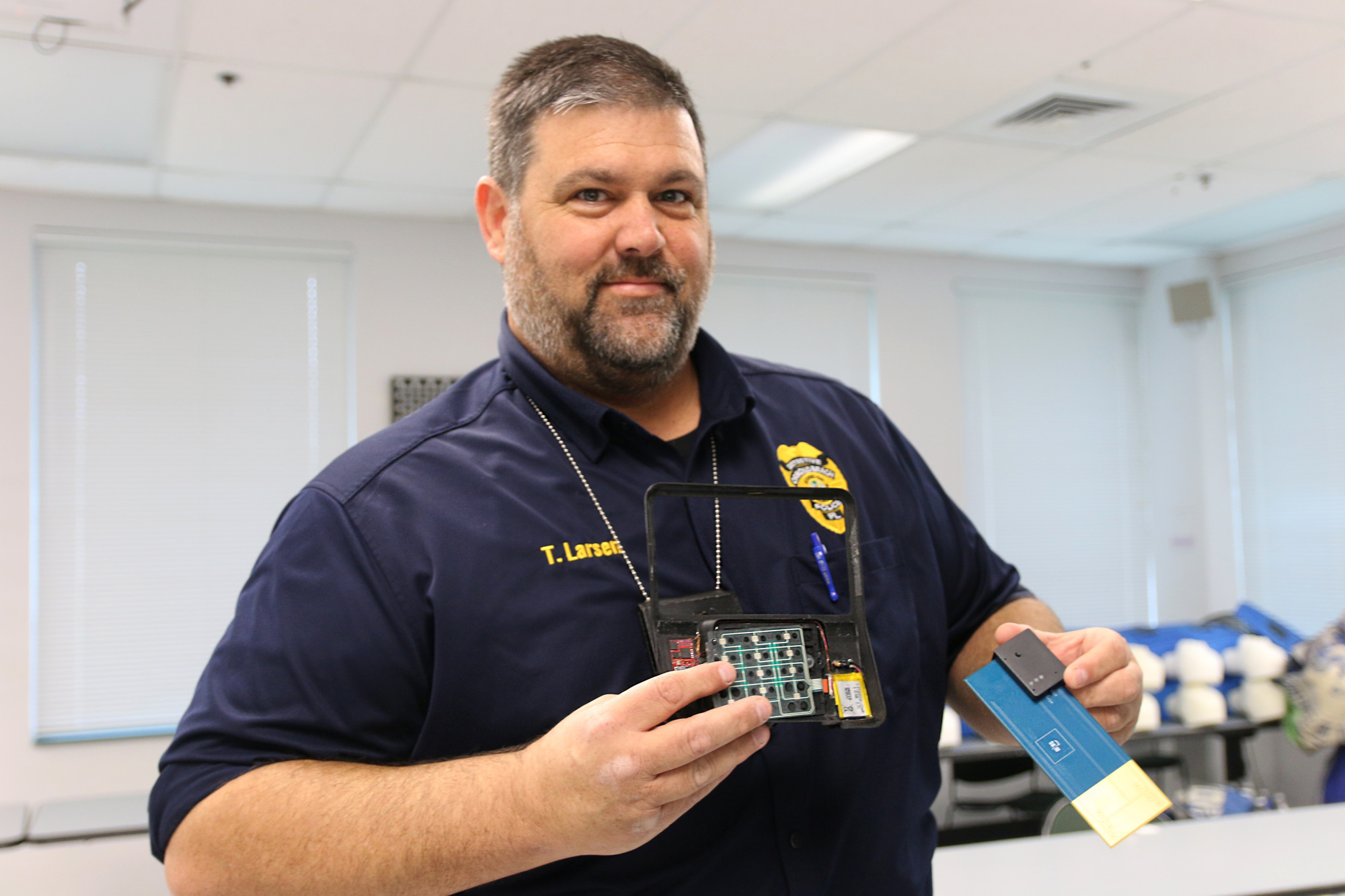 Sgt. Tom Larsen holds up an example of a skimmer removed from a local point of sale system along with the 