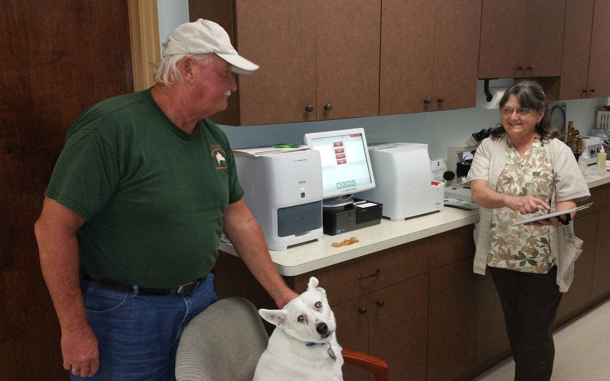 Eddie Petak, his dog Maisy, and Dr. Janet Brown reviewing Maisy’s blood work.
