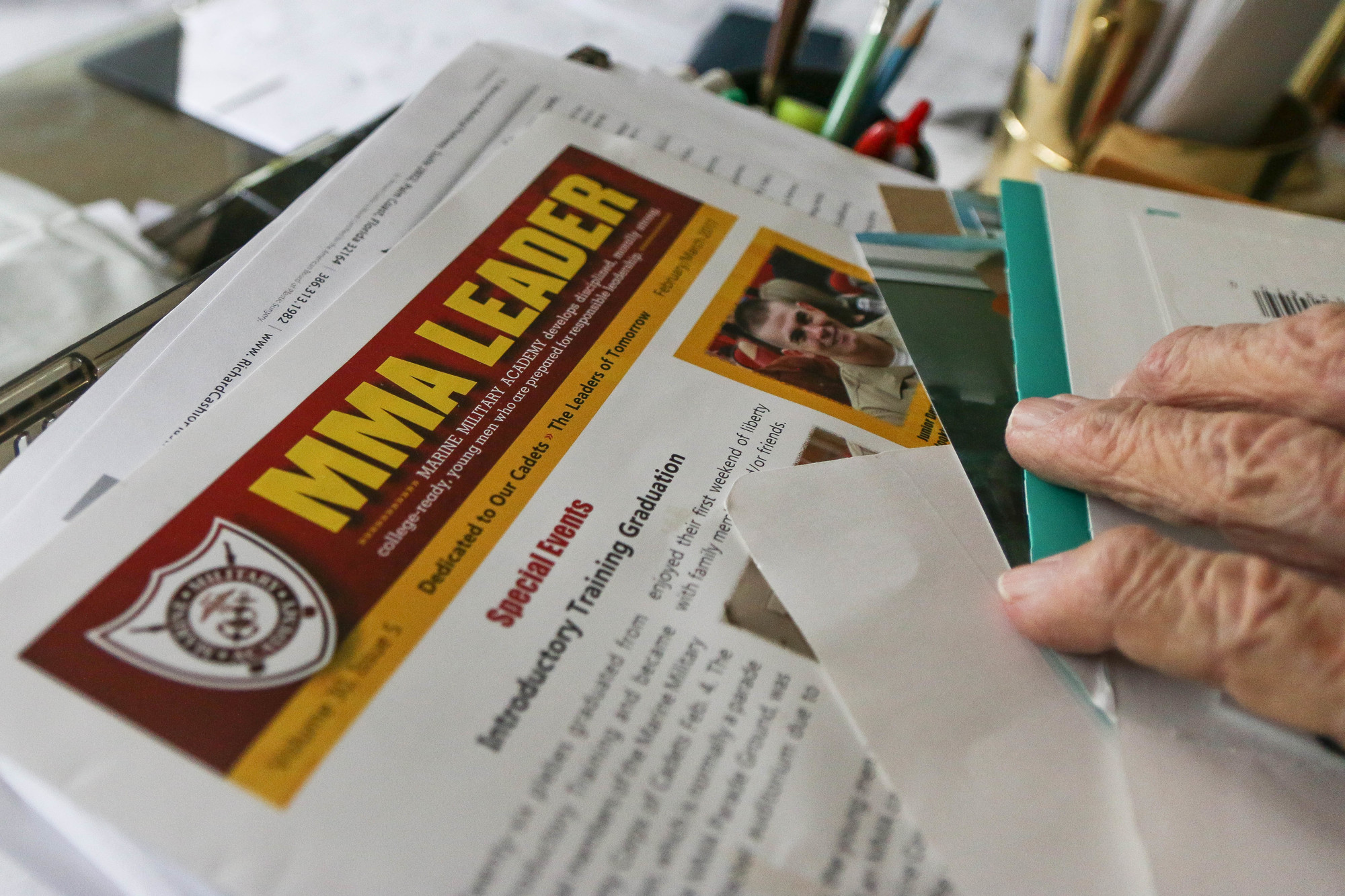 Bob Bey looks through a Marine Military Academy newsletter, in which he is featured. Photo by Paige Wilson