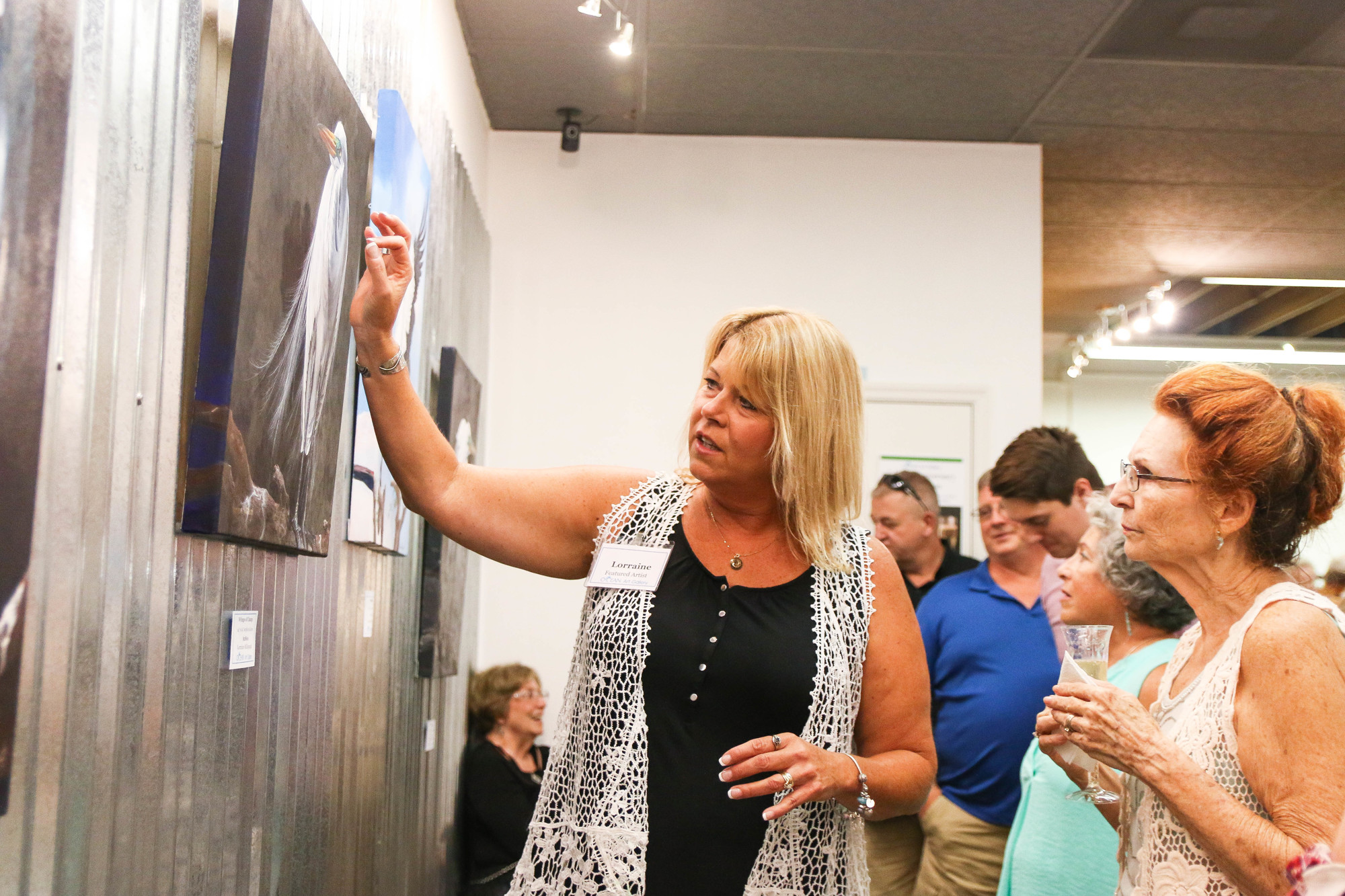 Artist Lorraine Millspaugh explains her painting process to Ormond Beach resident Joy Fritsch. Photo by Paige Wilson