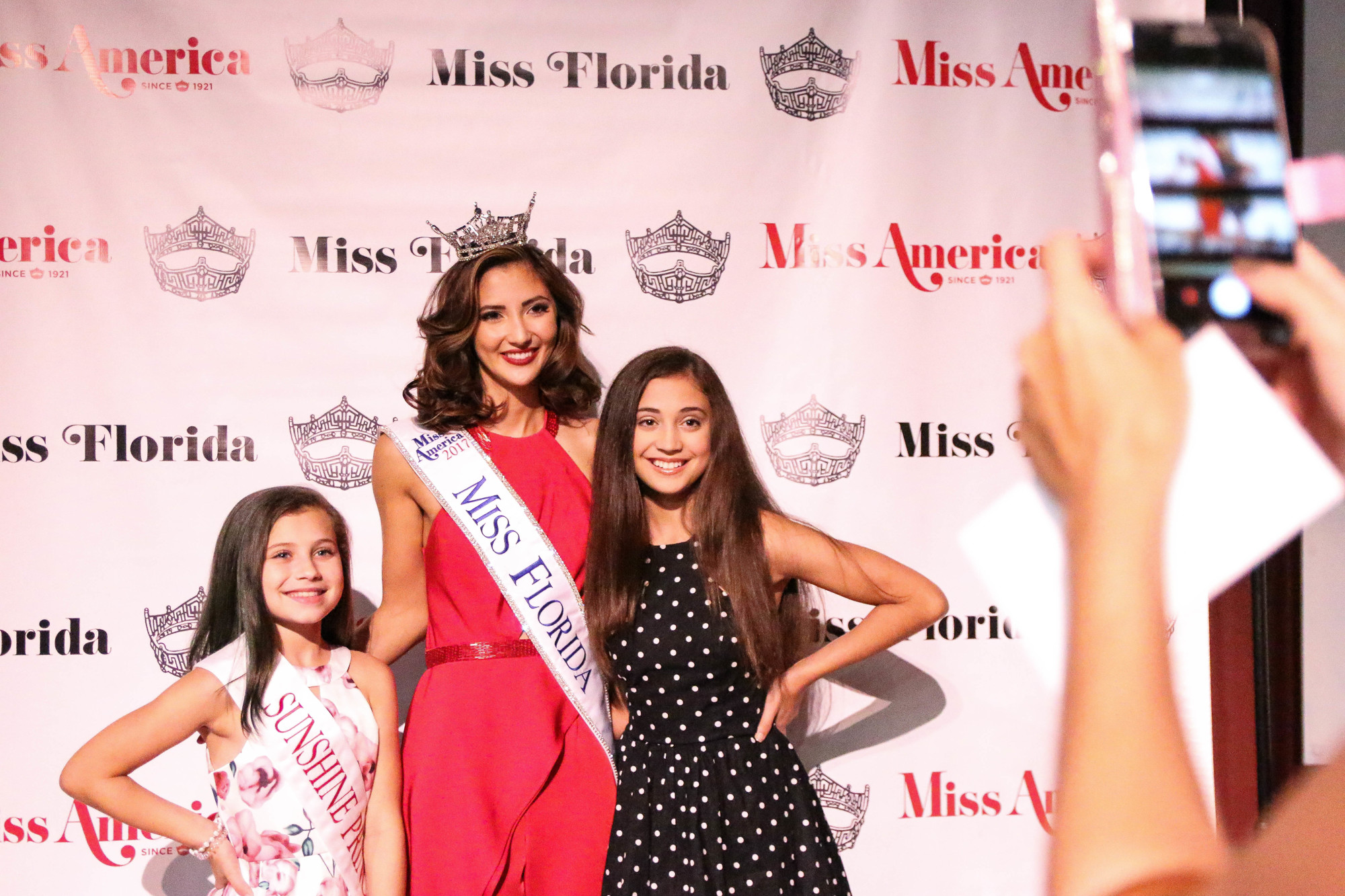 Ashlyn Palacios (left) and Alexis Palacios (right) take a photo with Miss Florida, Sara Zeng. Photo by Paige Wilson