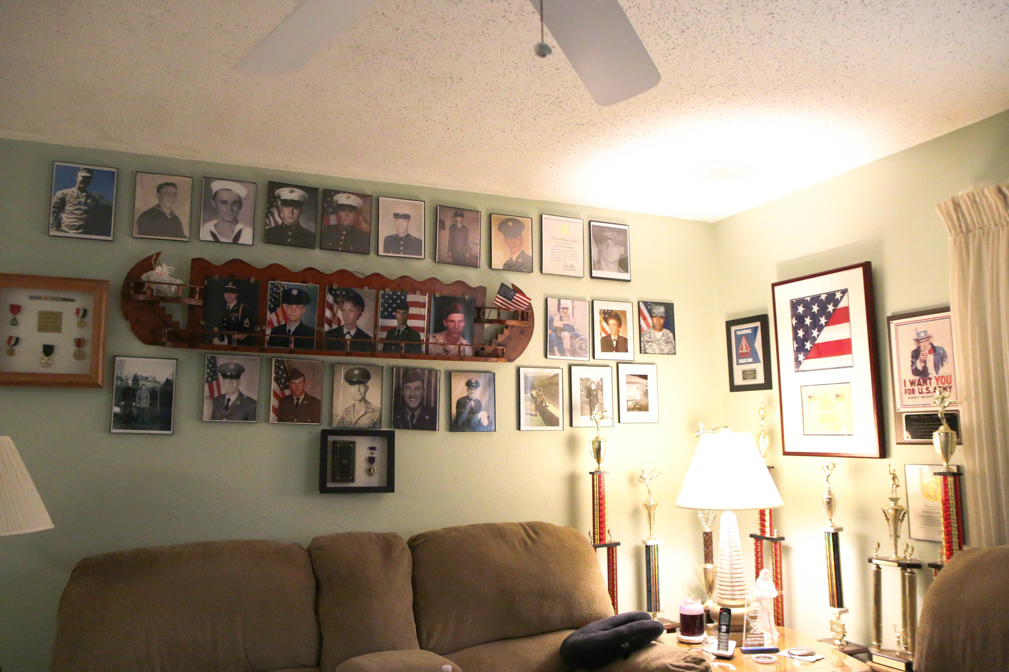 The Stewart's living room wall is filled with family members who are currently or were formerly in the U.S. Armed Forces. Photo by Paige Wilson
