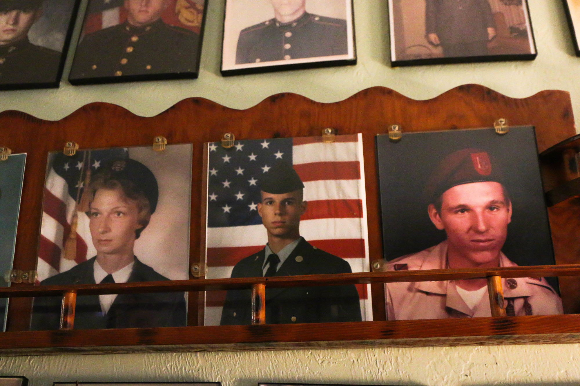 Photos of Joyce (left) and Mark Grubenhoff (right) and one of their sons, Kevin Grubenhoff (middle), are on display on the wall. Photo by Paige Wilson