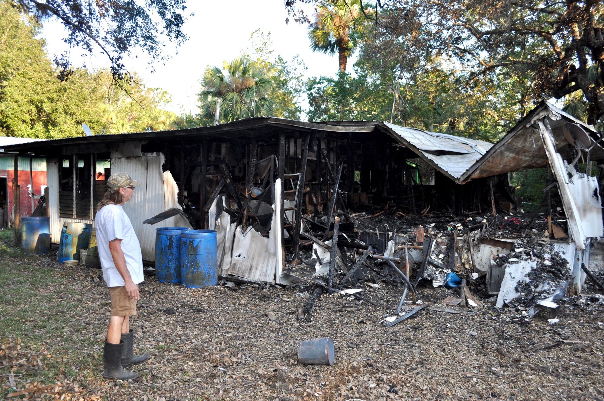 John Martin stands at the back of his mother's burned down house. Photo by Ray Boone