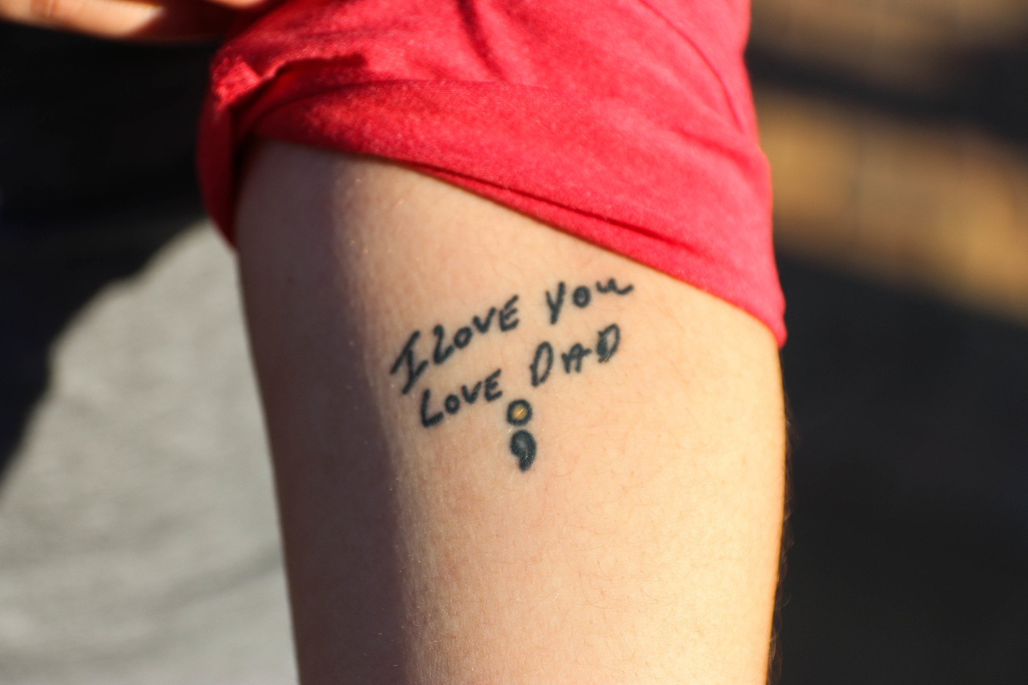 Melanie Cucco shows a tattoo she got in her father's handwriting to honor him after she lost him to suicide in 2008. Photo by Paige Wilson