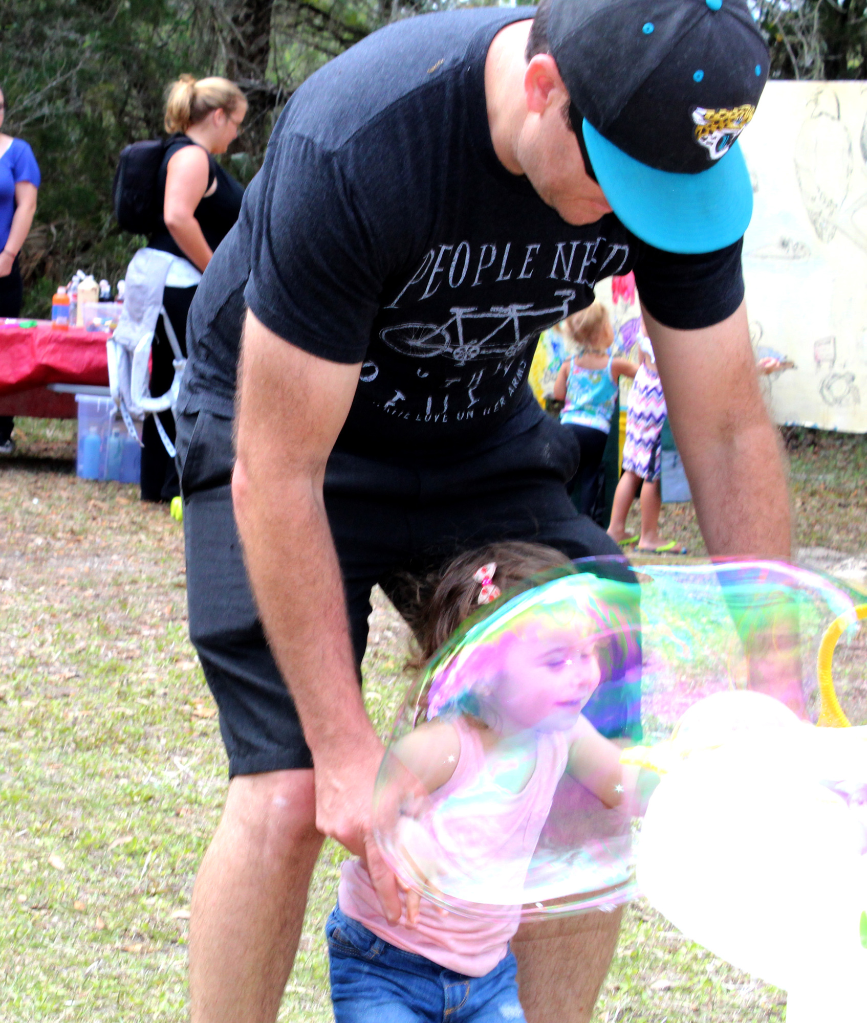 Fiona Arnold, 20 mos, looks through a huge bubble her dad, Robin Arnold held for her. Photo by Jacque Estes